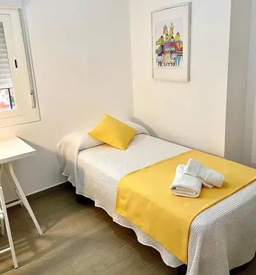a small room with two beds and a desk at Carmen viejo 12 in Sanlúcar de Barrameda