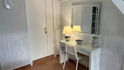 a room with a desk with a lamp and a mirror at Acogedor estudio junto playa, El Manantial in El Puerto de Santa María