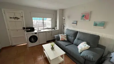 a living room with a couch and a table at Acogedor estudio junto playa, El Manantial in El Puerto de Santa María
