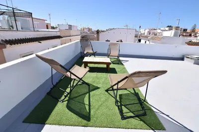three chairs and a table on a roof at Apartamentos Atlantida in Chipiona