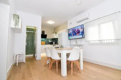 a kitchen and dining room with a table and chairs at Apartamentos Atlantida in Chipiona