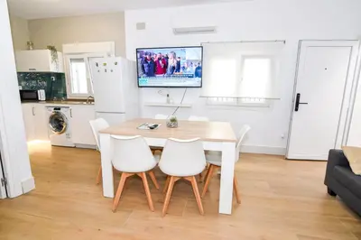 a kitchen and dining room with a table and chairs at Apartamentos Atlantida in Chipiona