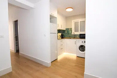 a kitchen with white cabinets and a washer and dryer at Apartamentos Atlantida in Chipiona