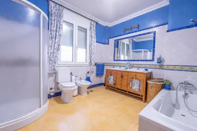 a blue and white bathroom with a toilet and a sink at VILLA CAPITAN in Sanlúcar de Barrameda