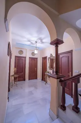 an archway in a hallway with wooden doors at VILLA CAPITAN in Sanlúcar de Barrameda