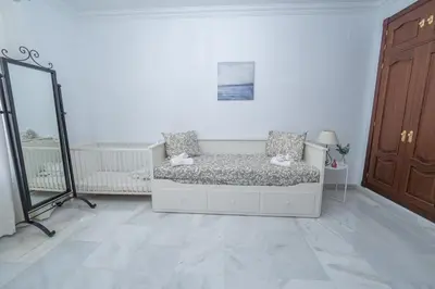 a white room with a bed and a mirror at VILLA CAPITAN in Sanlúcar de Barrameda