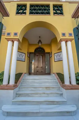 a yellow building with stairs leading to a door at VILLA CAPITAN in Sanlúcar de Barrameda