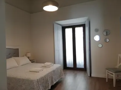 a bedroom with a bed with two towels on it at CASA PALACIO CABALLEROS 7 con Parking in Sanlúcar de Barrameda