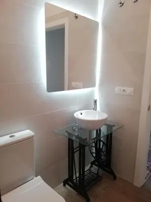 a bathroom with a sink and a mirror and a toilet at CASA PALACIO CABALLEROS 7 con Parking in Sanlúcar de Barrameda