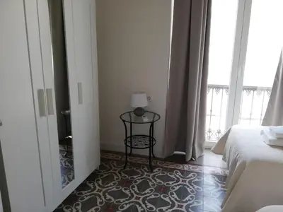 a bedroom with a bed and a table and a window at CASA PALACIO CABALLEROS 7 con Parking in Sanlúcar de Barrameda