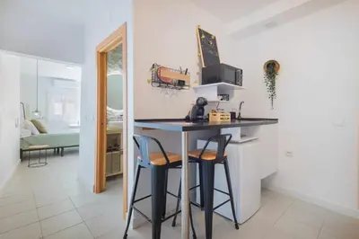 a kitchen with a counter and stools in a room at Jacuzzi Amanecer de Plata Decoración Romántica in Chiclana de la Frontera