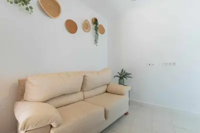 a living room with a couch and hats on the wall at Jacuzzi Amanecer de Plata Decoración Romántica in Chiclana de la Frontera
