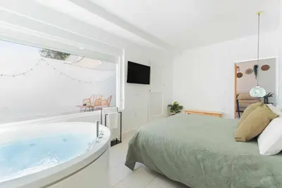 a bedroom with a bed and a bath tub at Jacuzzi Amanecer de Plata Decoración Romántica in Chiclana de la Frontera