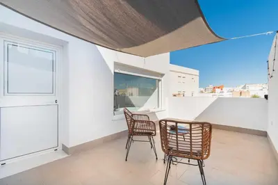 a balcony with two chairs and a table and a window at Jacuzzi Amanecer de Plata Decoración Romántica in Chiclana de la Frontera