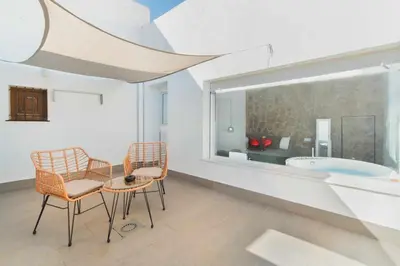 a room with a table and chairs and a tub at Jacuzzi Amanecer de Plata Decoración Romántica in Chiclana de la Frontera