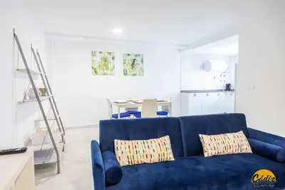 a blue couch with two pillows in a living room at Loft Santa María by Cadiz Time in Cádiz