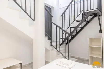 a staircase in a living room with white walls and a stair case at Loft Santa María by Cadiz Time in Cádiz