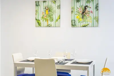 a white dining room with a white table and chairs at Loft Santa María by Cadiz Time in Cádiz