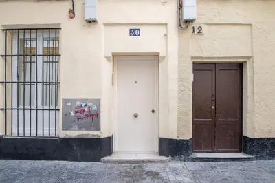 two doors on the side of a building with graffiti at Estudio Al Sur de Cádiz in Cádiz
