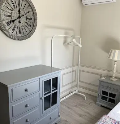 a bedroom with a clock on the wall and a dresser at Ático San Juan in Sanlúcar de Barrameda