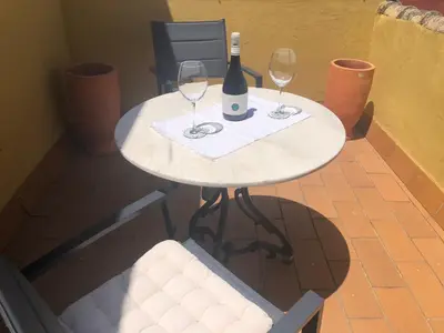 a white table with two glasses of wine on it at Ático San Juan in Sanlúcar de Barrameda