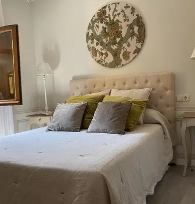 a bedroom with a large bed with green pillows at Ático San Juan in Sanlúcar de Barrameda