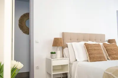 a bedroom with a bed with white pillows at Apartamentos Casa Macías in Cádiz