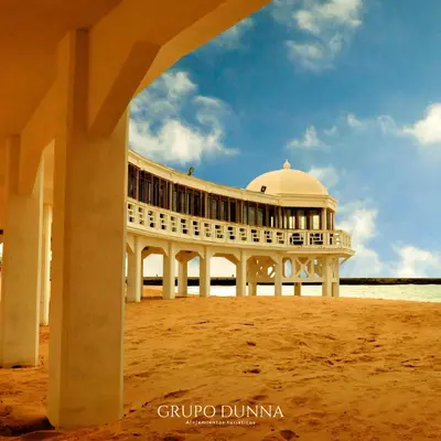 a building on the beach with a building in the sand at Apartamentos Casa Macías in Cádiz