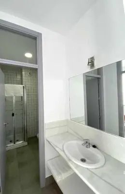 a white bathroom with a sink and a mirror at Apartamentos Casa Macías in Cádiz