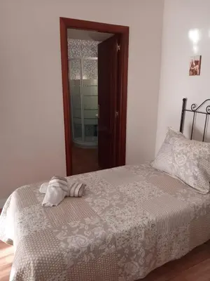 a bedroom with a bed with a towel on it at La Casa de Pepa in Jerez de la Frontera
