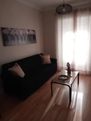 a living room with a black couch and a glass table at La Casa de Pepa in Jerez de la Frontera