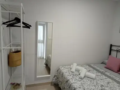 a bedroom with a bed and a mirror at La Casa de Pepa in Jerez de la Frontera