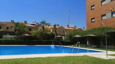 a large blue swimming pool next to a building at Ático Love in Jerez de la Frontera