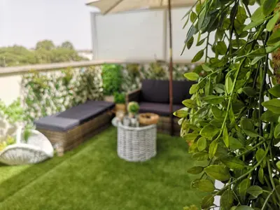 a garden with a bench and an umbrella at Ático Love in Jerez de la Frontera