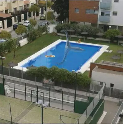 a large swimming pool with a dolphin in it at Ático Love in Jerez de la Frontera