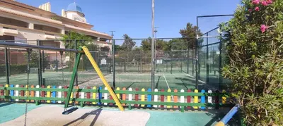 a playground with a tennis court in the background at Costa Ballena!!! House on Mediterranean Coast with pool and golf!!! Dúplex!!! in Costa Ballena