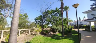a yard with palm trees and a fence at Costa Ballena!!! House on Mediterranean Coast with pool and golf!!! Dúplex!!! in Costa Ballena