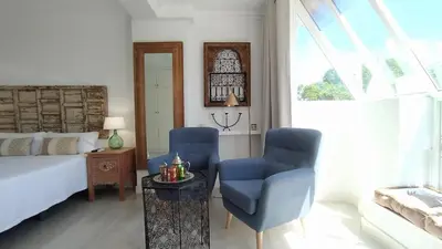 a bedroom with two blue chairs and a bed at Sherryflat Luna in Jerez de la Frontera