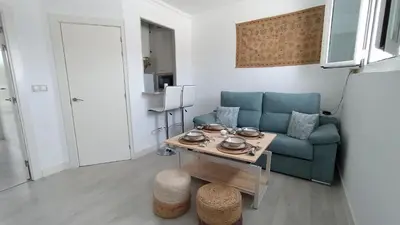a living room with a blue couch and a table at Sherryflat Luna in Jerez de la Frontera
