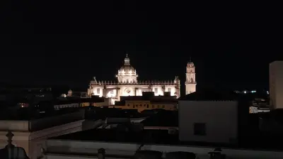 a lit up building with a clock tower at night at Sherryflat Luna in Jerez de la Frontera