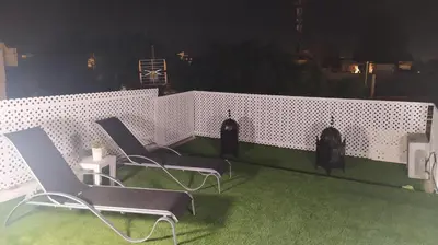 two chairs and a table on a balcony at night at Sherryflat Luna in Jerez de la Frontera