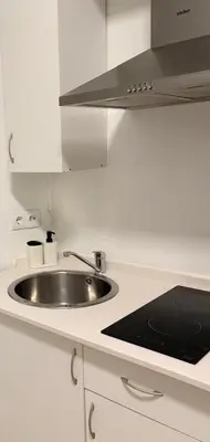a white kitchen with a sink and a stove at Estudio Soniquete in Jerez de la Frontera