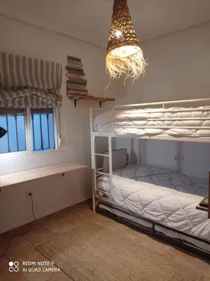 a bedroom with two bunk beds and a chandelier at VILLA SANTA CLARA in Chiclana de la Frontera