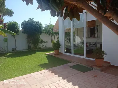 a house with a large window and a yard at VILLA SANTA CLARA in Chiclana de la Frontera
