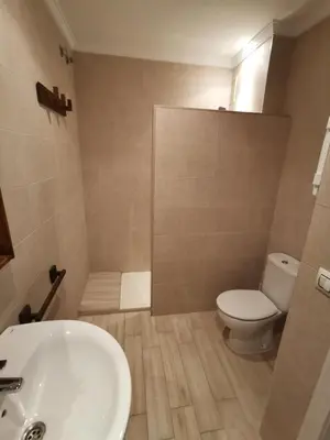 a bathroom with a white sink and a toilet at Apartamento Wifi, Garaje Centro y playa in Chipiona