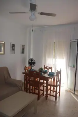 a living room with a table and chairs and a couch at Apartamento Wifi, Garaje Centro y playa in Chipiona