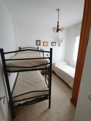 two bunk beds in a room with a window at Apartamento Wifi, Garaje Centro y playa in Chipiona