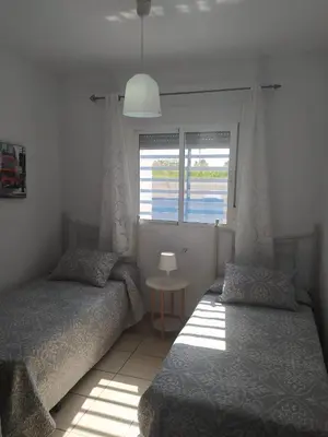 a bedroom with two twin beds and a window at Casa Enrique in Cádiz