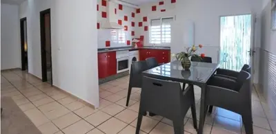 a kitchen with red cabinets and a table and chairs at Casa Enrique in Cádiz