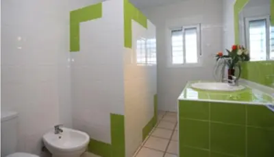 a green and white bathroom with a toilet and sink at Casa Enrique in Cádiz